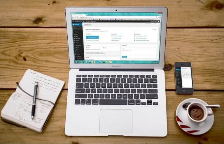 A laptop displays the WordPress admin dashboard.