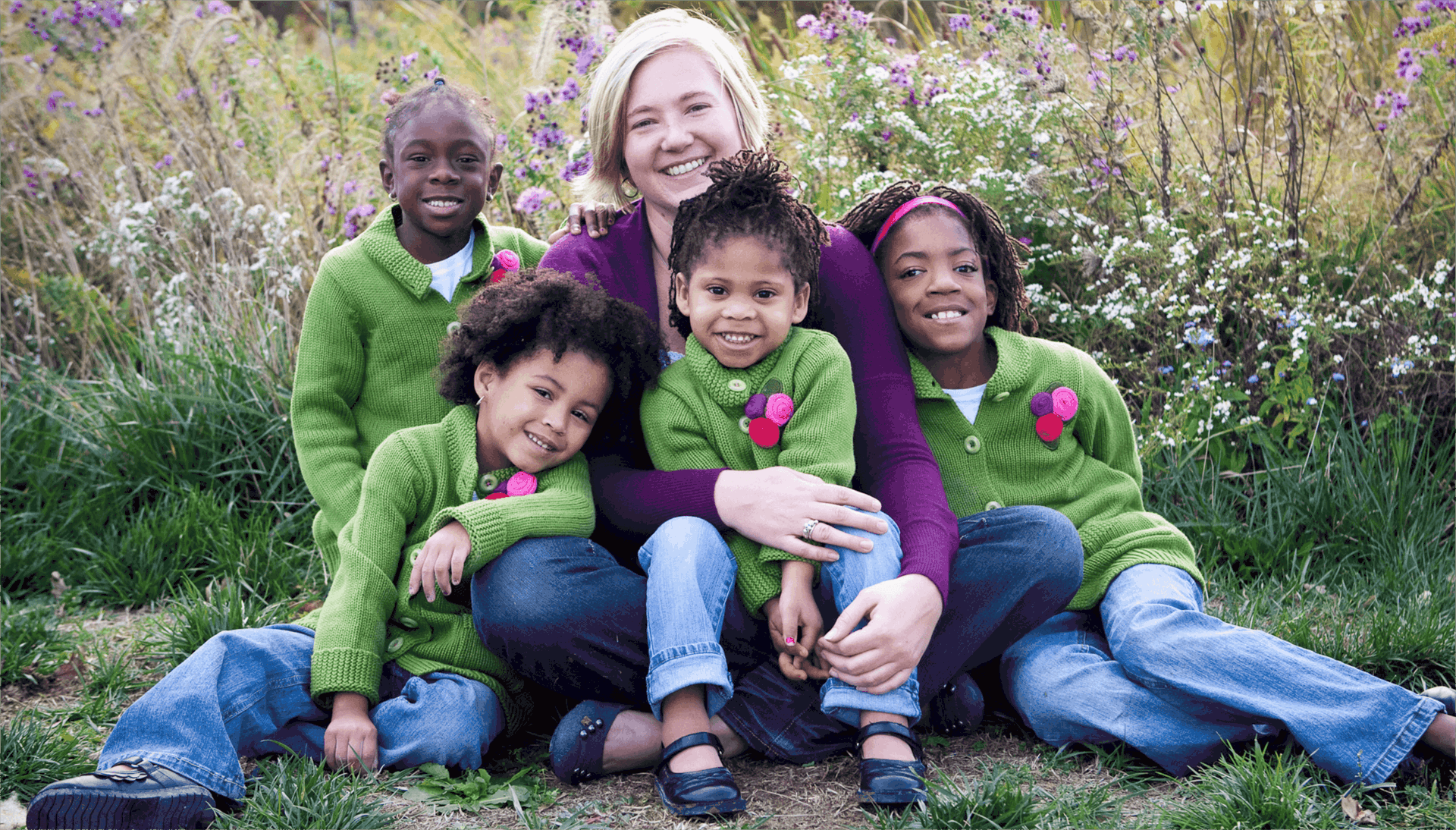 A woman poses with her four adopted children