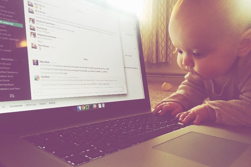 A baby looking at a laptop