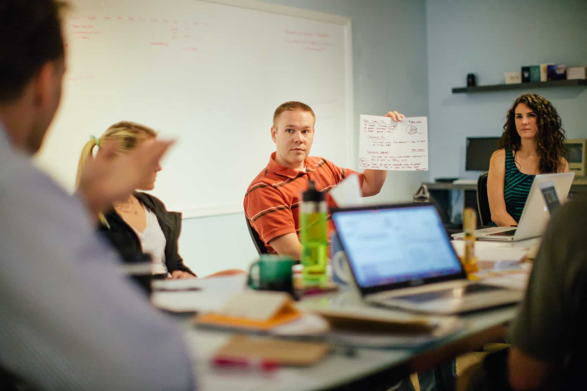 A man holds up a diagram during a CauseLabs strategic workshop.