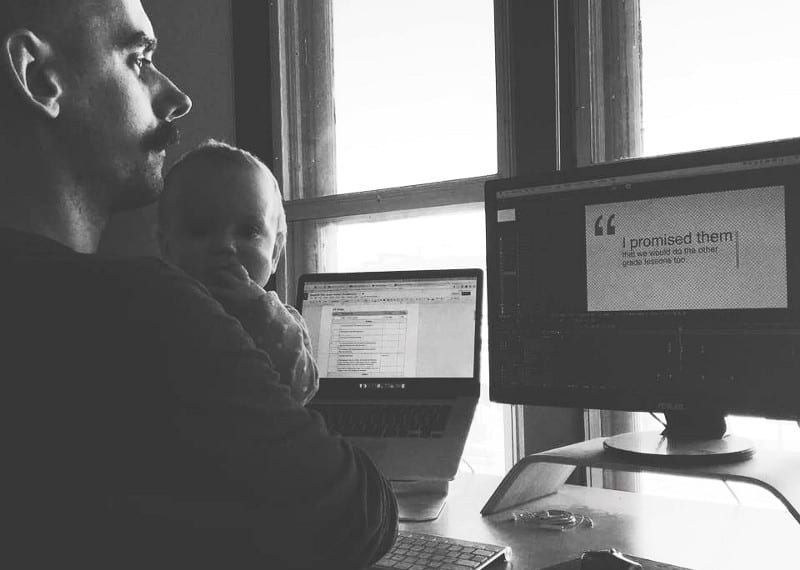 A man and baby in an office working on motion design at a computer