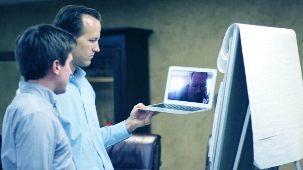 Two men video conferencing during an HCD workshop working through a problem statement and problem immersion.