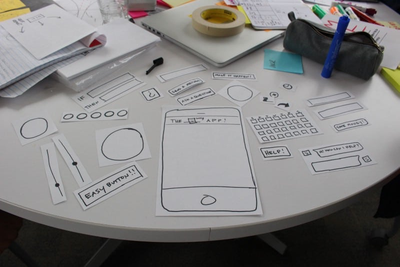 Drawn and cutout illustrations of an app and its features during prototyping