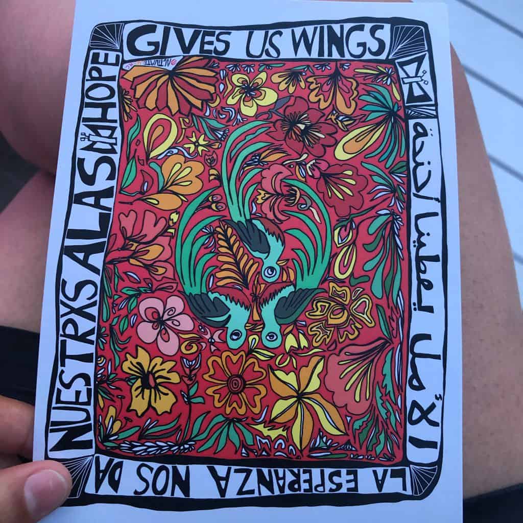 local artwork that has colorful flowers and birds and says Give Us Wings