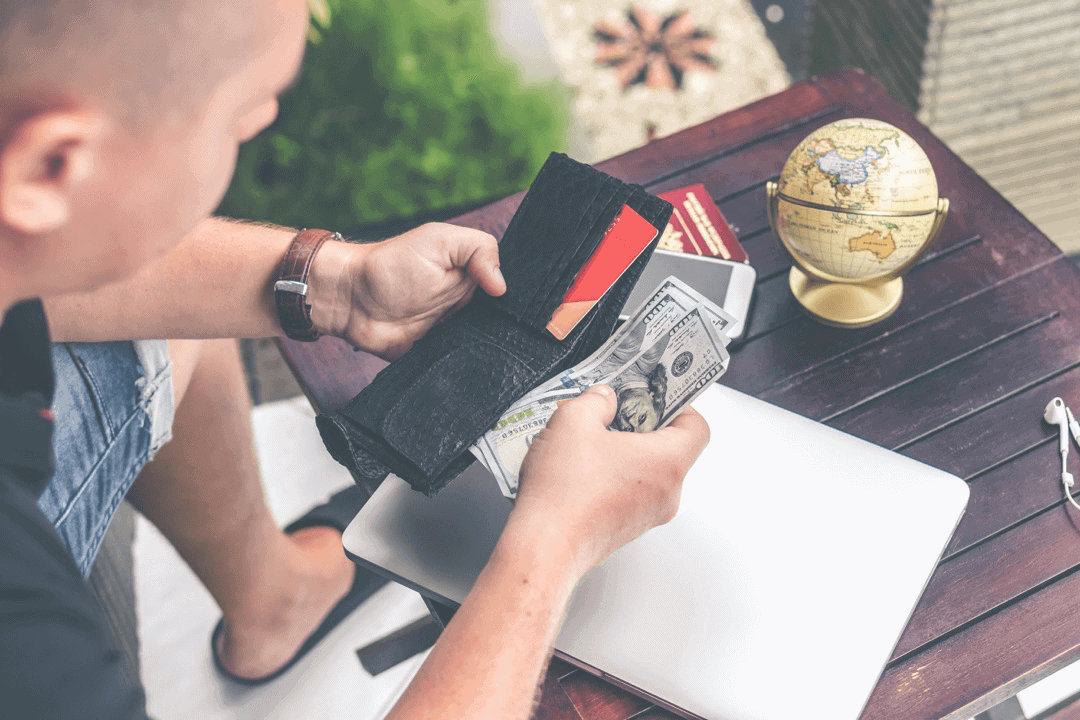 A person counting the money in their wallet.