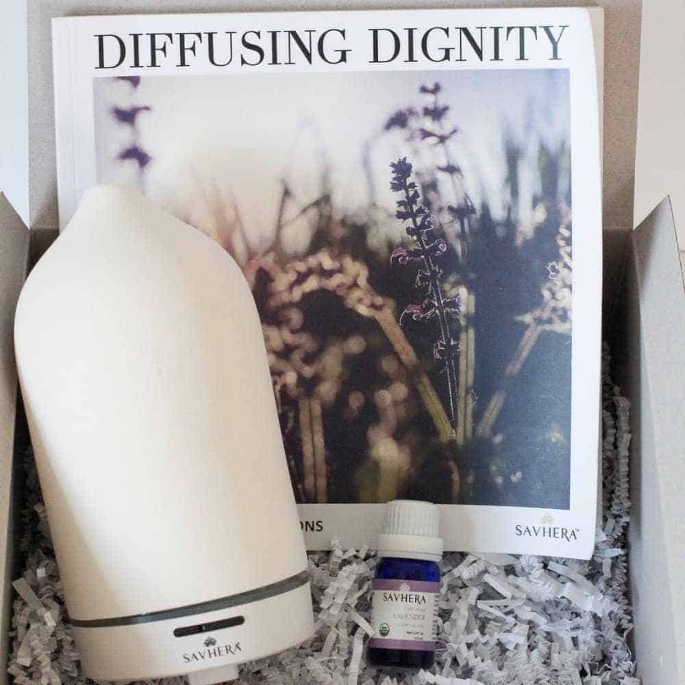 Savhera diffuser displayed with book titled "Diffusing Dignity"