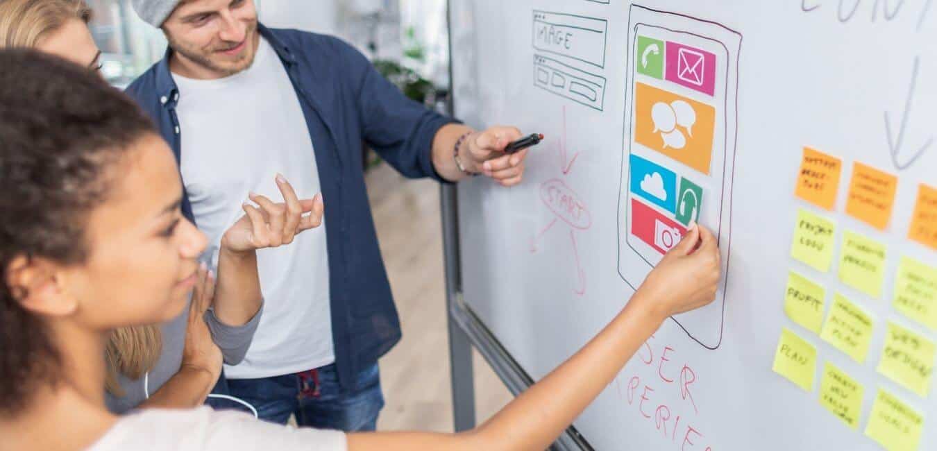 A team working on website strategy on a whiteboard