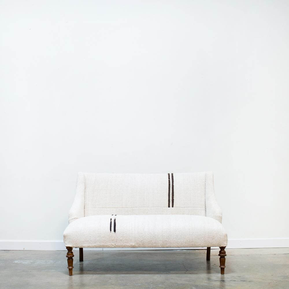 A white colored sofa looking comfortable to set with wooden legs from Loot Finer Goods