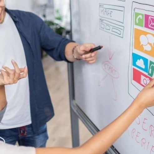 A team working on website strategy on a whiteboard