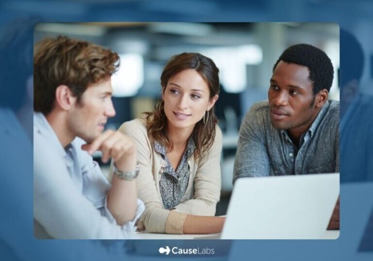 Three people sit at a table in an office, engaged in conversation, with a laptop open in front of them. The CauseLabs logo appears at the bottom of the image.