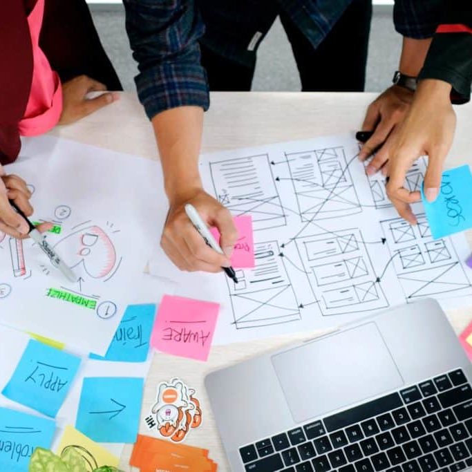 Growth-Driven Design: A close up of three people's hands as they plan out website content.