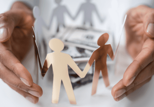 Hands with a paper man chain holding hands with money in the center