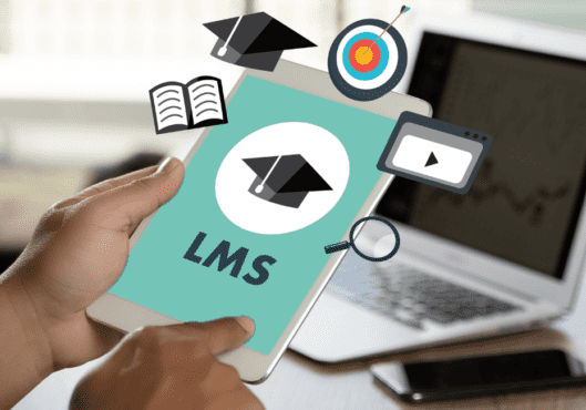 Man holding tablet with Learning Management System (LMS) screen in front of laptop and mobile phone