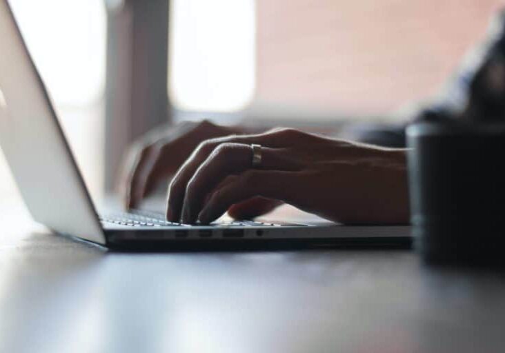 Hands typing on a laptop