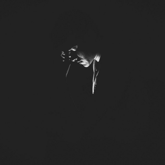 A man in the dark with light illuminating his face.