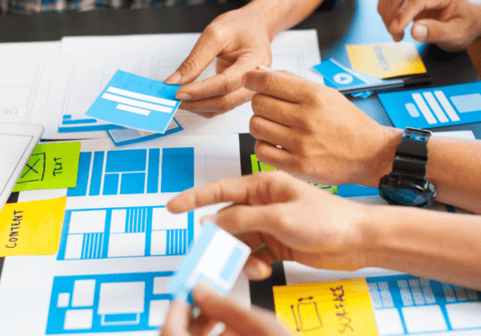 Web designers in meeting discussing and planning with various of notes at desk