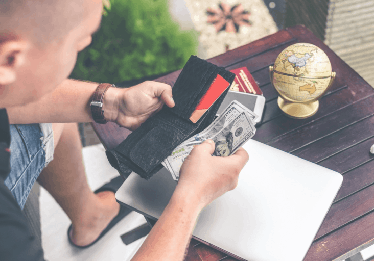 A person counting the money in their wallet.