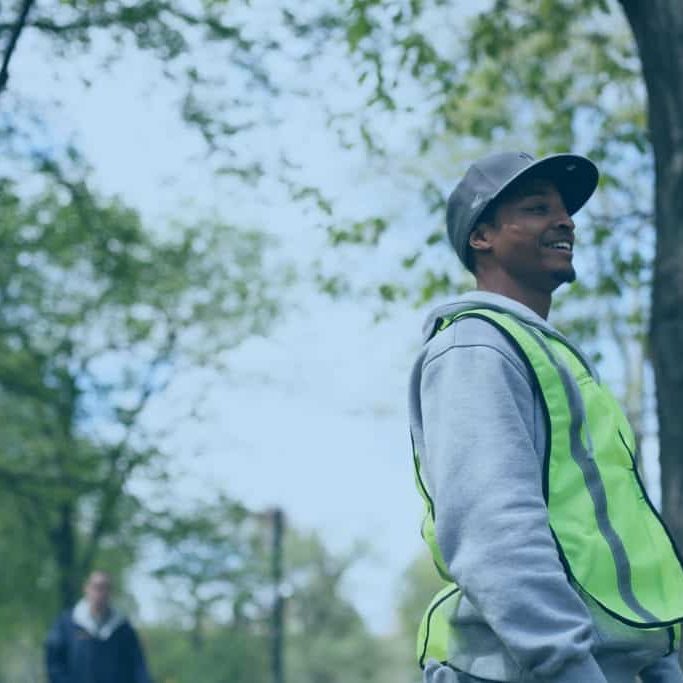 A working in a reflective vest working outdoors.