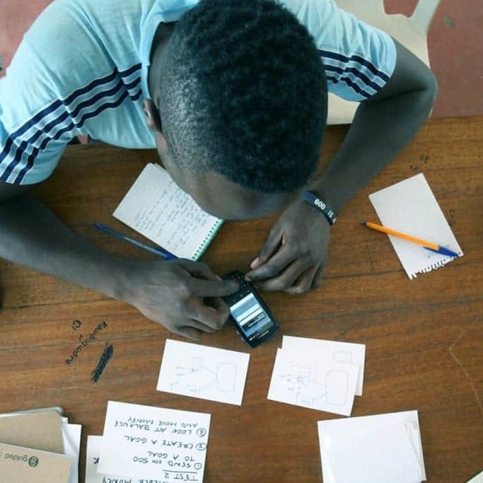 A young man uses a cell phone to test a prototype for a CauseLabs project.