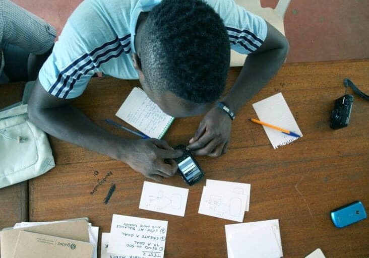 A young man uses a cell phone to test a prototype for a CauseLabs project.