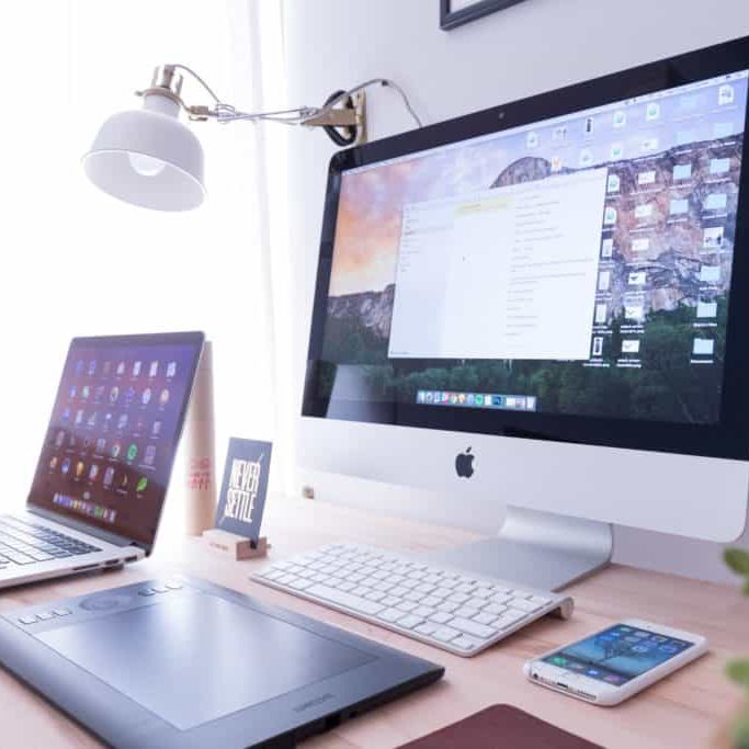 Showcasing supported browsers with an image of different devices on a desk including an iMac, a laptop, a tablet, and a phone.