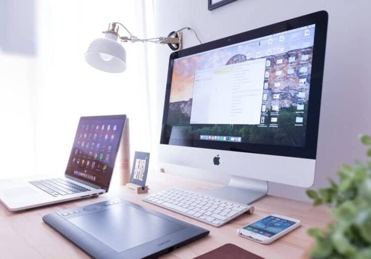 Showcasing supported browsers with an image of different devices on a desk including an iMac, a laptop, a tablet, and a phone.