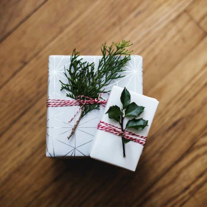 Two wrapped packages with greenery on top