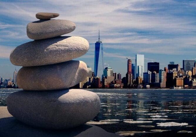Stacked stones by the water with a city skyline