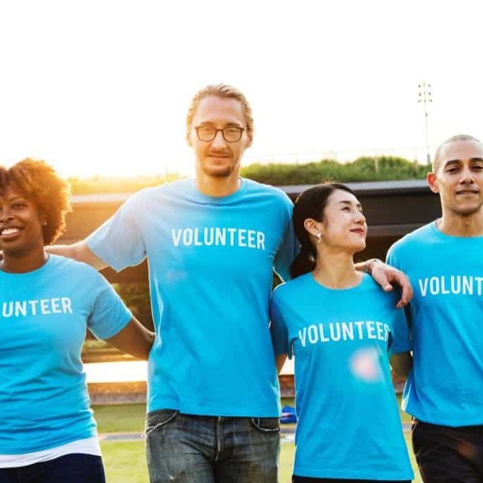 A diverse group of people wearing Volunteer shirts.