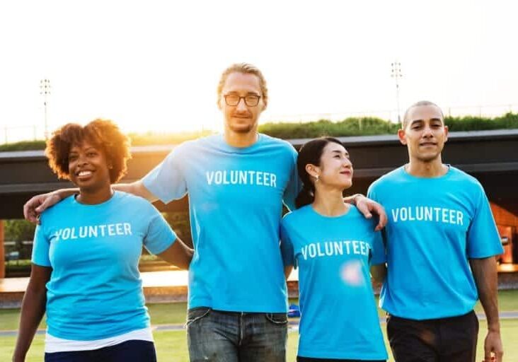 A diverse group of people wearing Volunteer shirts.