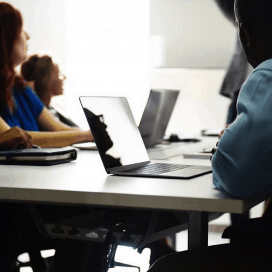 A diverse group of people on computers.