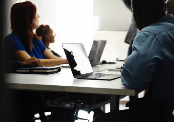 A diverse group of people on computers.